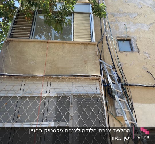 סולם מתכת צמוד לקיר עם כבלים חשמליים